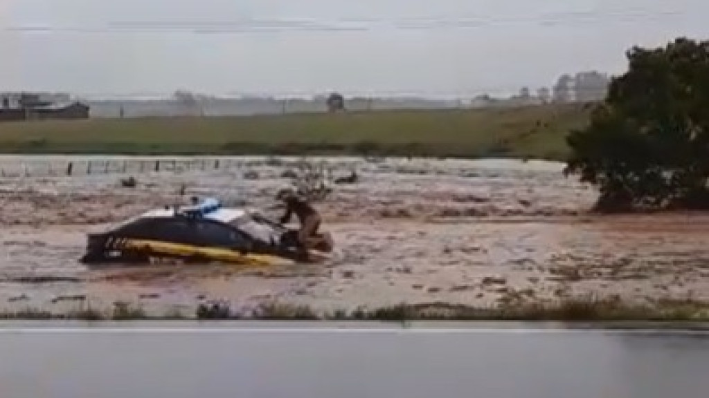 VÍDEO: Barragem estoura e policial sobe em viatura para tentar escapar, no RS
