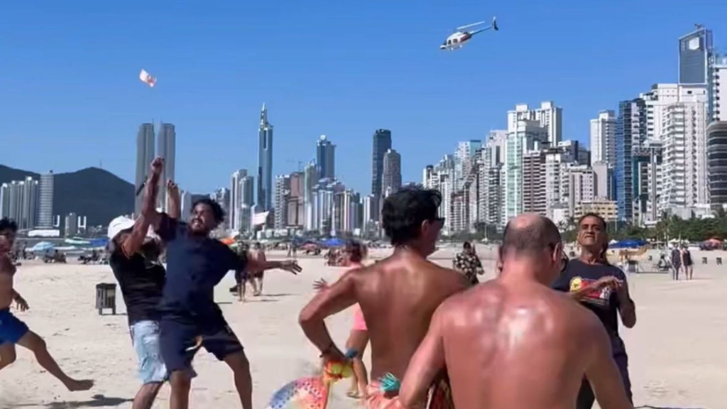 VÍDEO - Helicóptero 'joga dinheiro' para pessoas na praia de Balneário Camboriú